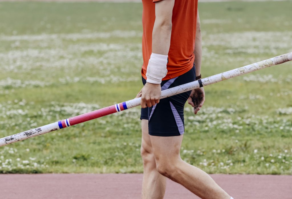 male athlete holding a pole during a competition in athletics